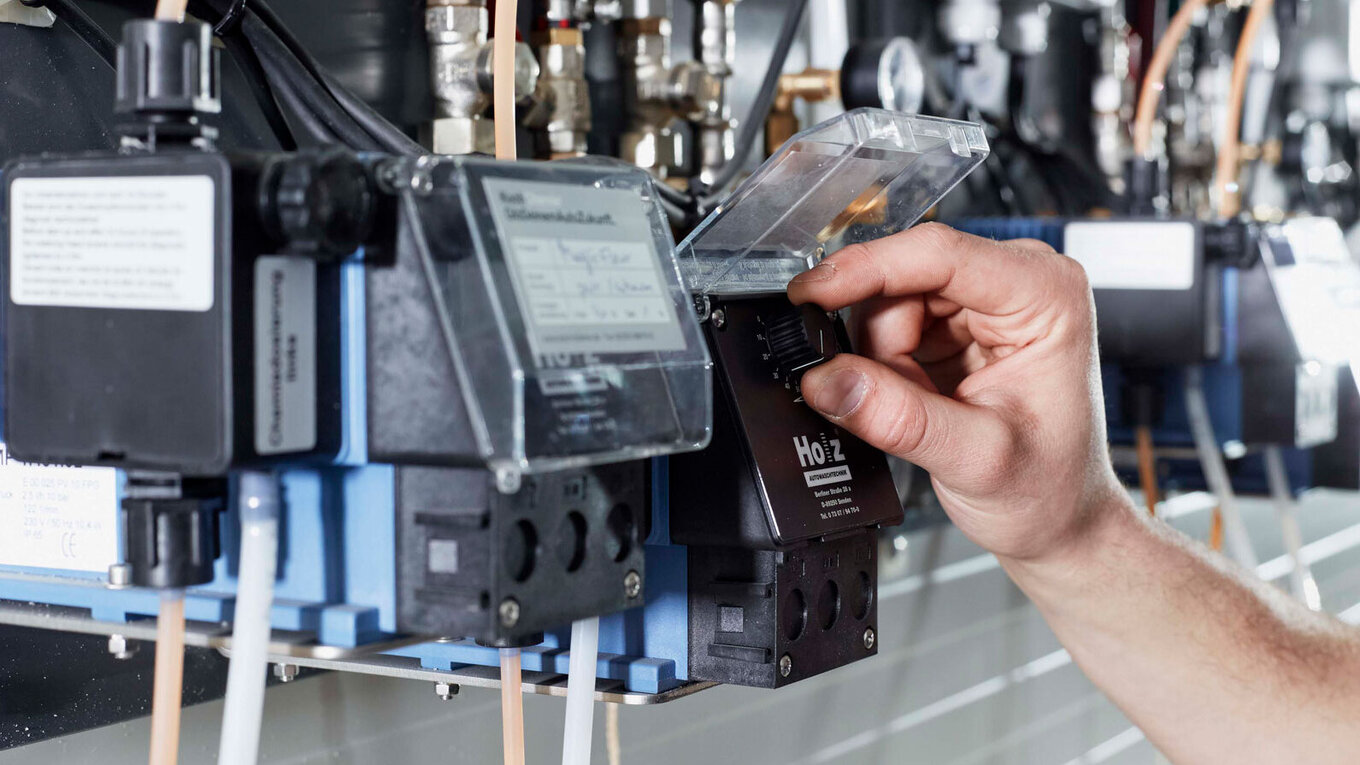 Close-up of an employee's hand operating one of our machines