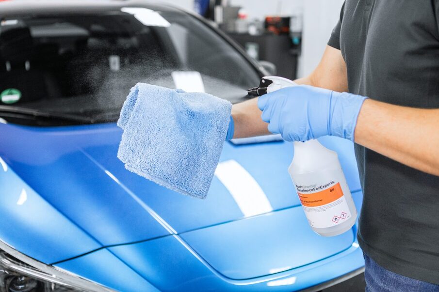 An employee spraying a liquid on a cleaning cloth
