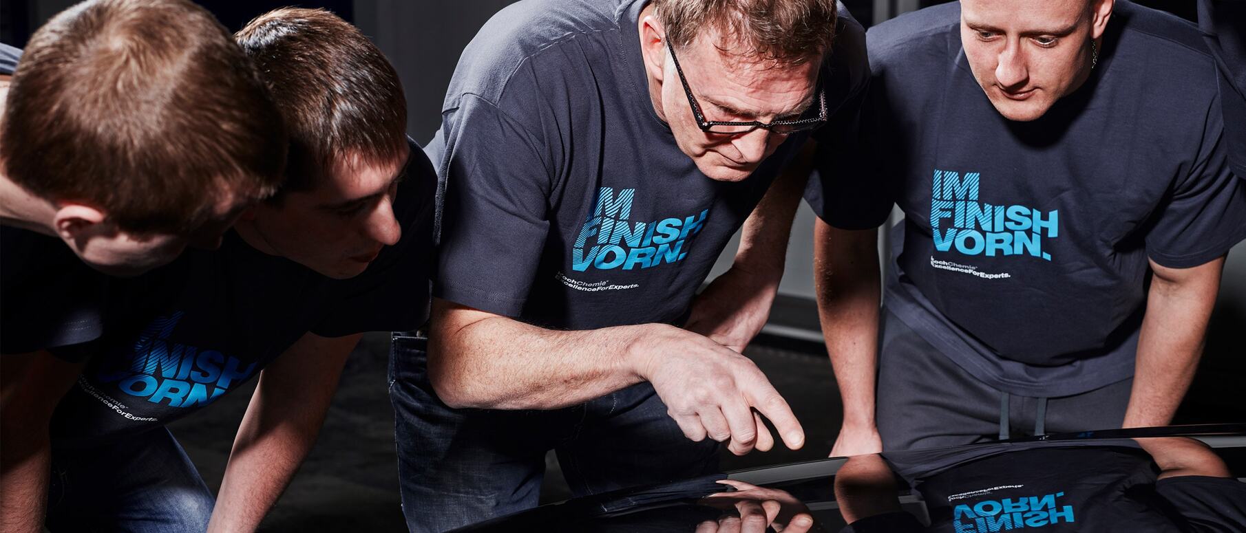 Employees check the paintwork of a vehicle during a training course