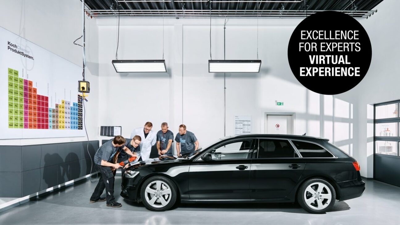 Employees applying products on a black car’s engine hood